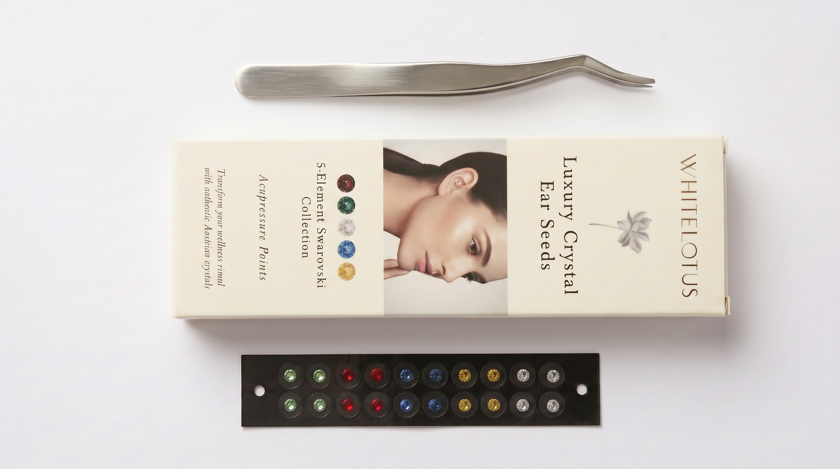 Box mit luxuriösen Kristall-Ohrensteckern mit Pinzette und Farbkarte auf weißem Hintergrund